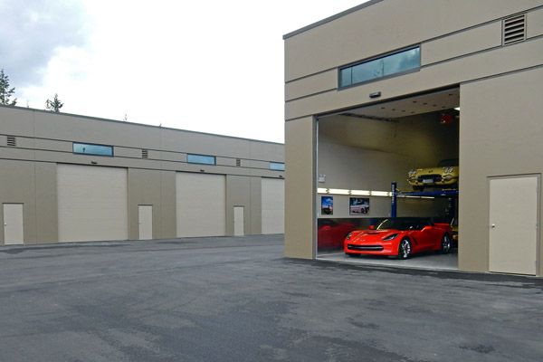 Guy Garages with Bay Door Open and Corvette Showing